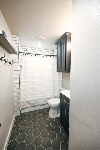 a bathroom with a toilet and a shower