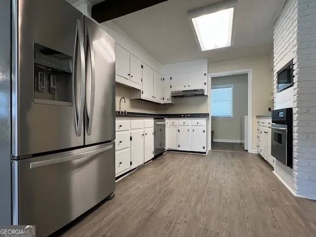 a kitchen with stainless steel appliances a refrigerator sink and cabinets