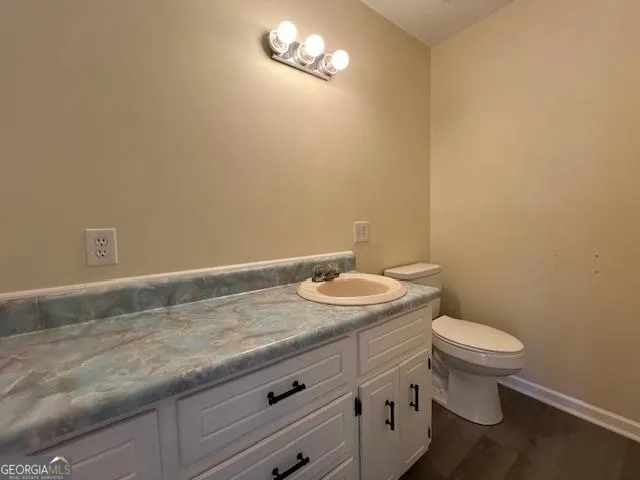 a bathroom with a granite countertop toilet and a sink