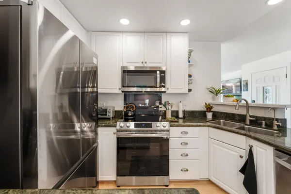 a kitchen with a sink stainless steel appliances and cabinets