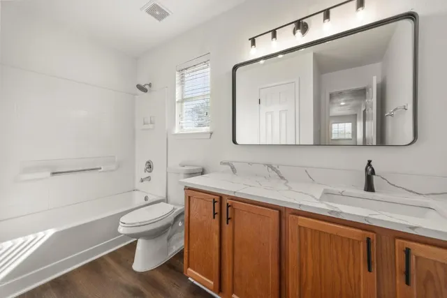 an empty room with wooden floor and a ceiling fan