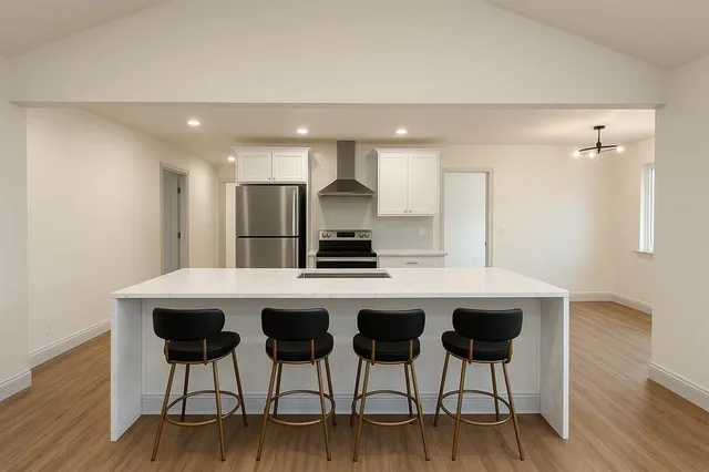 a kitchen with a table chairs refrigerator and cabinets