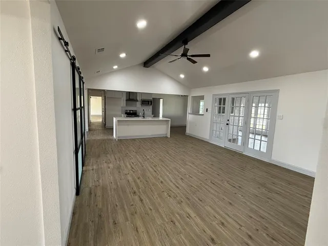 a view of a big room with wooden floor and windows