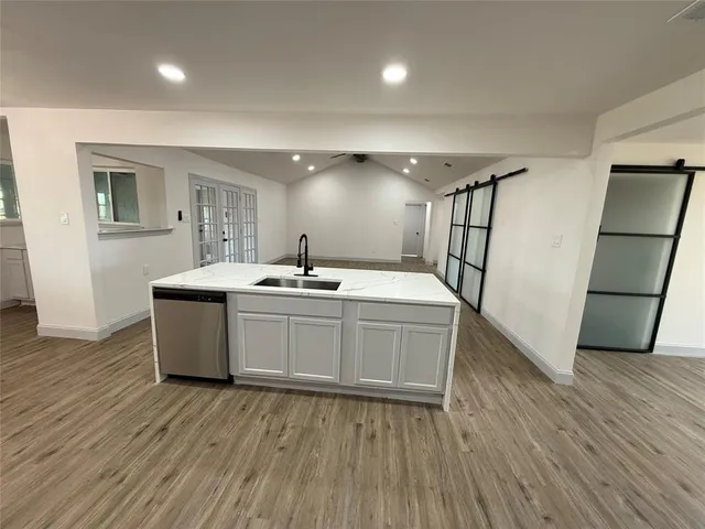 a kitchen with a sink and wooden floor