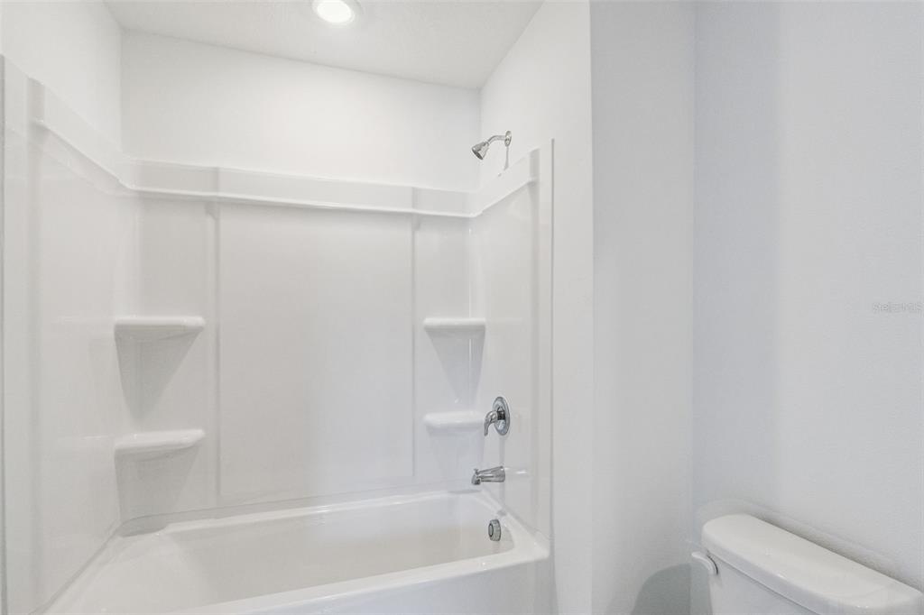 3613 Spire Drive Davenport, FL 33837 - Photo 12 of 20 a bathroom with a bathtub and toilet