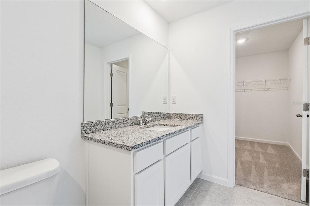 3613 Spire Drive Davenport, FL 33837 - Photo 13 of 20 a bathroom with a granite countertop sink and a mirror