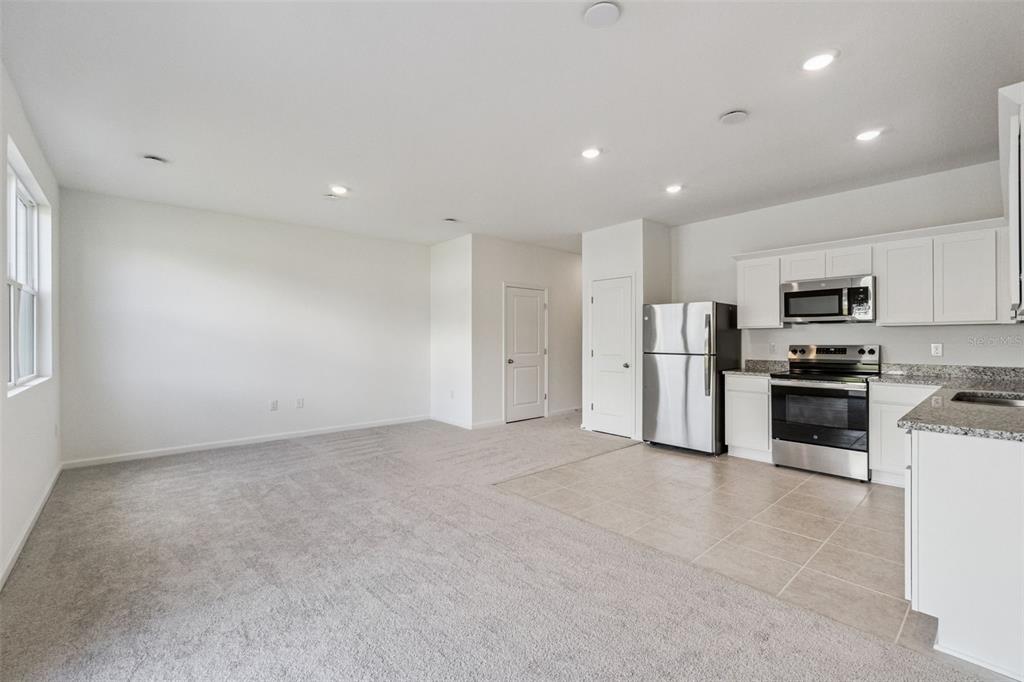 3613 Spire Drive Davenport, FL 33837 - Photo 3 of 20 a view of kitchen with stainless steel appliances refrigerator oven stove microwave and cabinets