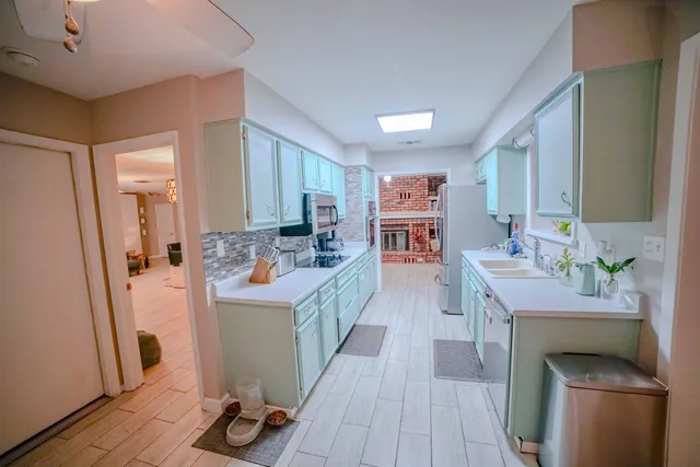 a kitchen with kitchen island a sink stove and refrigerator