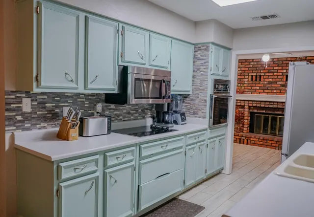 a kitchen with stainless steel appliances granite countertop a sink stove and cabinets