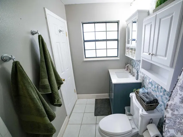 a bathroom with a sink a toilet a mirror and shower