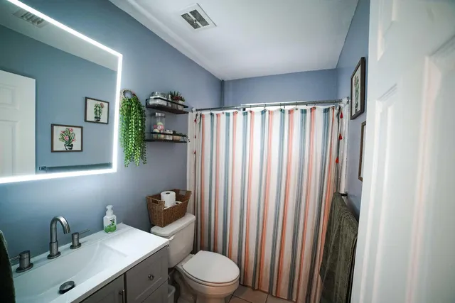 a bathroom with a toilet a sink and mirror