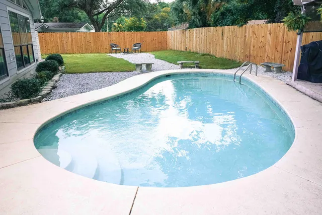 a view of a swimming pool with a yard