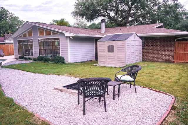a view of a house with backyard and sitting area