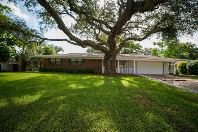 a view of house with a backyard
