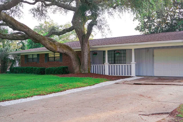 a front view of a house with yard and green space