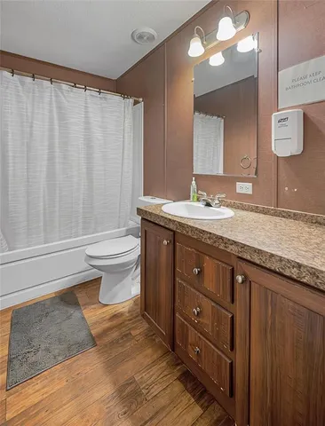 a bathroom with a granite countertop sink toilet a mirror and a shower