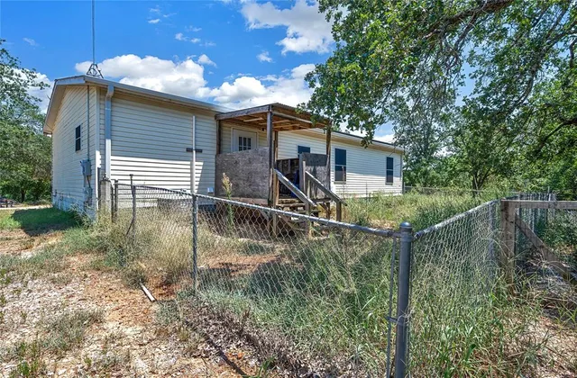 a view of house with backyard and swimming pool