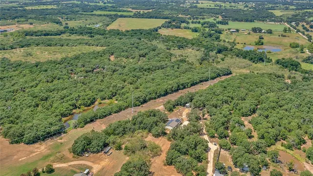 an aerial view of a house with a yard and lake view