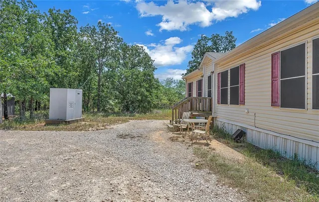 a backyard of a house with table and chairs