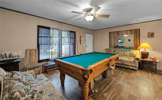 a room with furniture pool table and flat screen tv