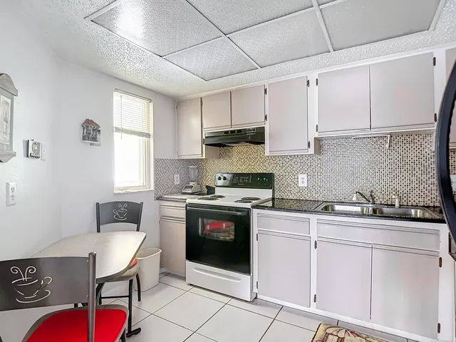 a kitchen with stainless steel appliances granite countertop a stove a sink dishwasher and cabinets with wooden floor