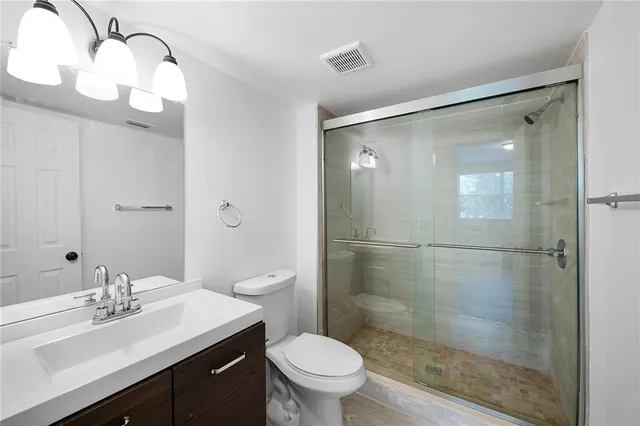 a bathroom with a sink a toilet and shower