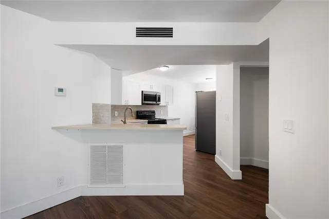 a kitchen with a refrigerator and a stove top oven