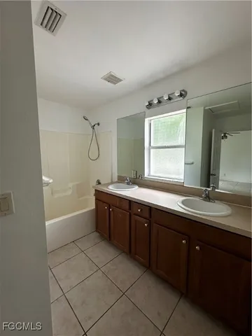 a large bathroom with a double vanity sink a mirror and a bathtub