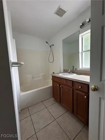 a bathroom with a tub a sink and mirror