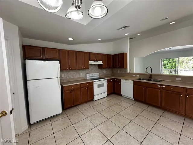 a large kitchen with a refrigerator a sink dishwasher and a stove