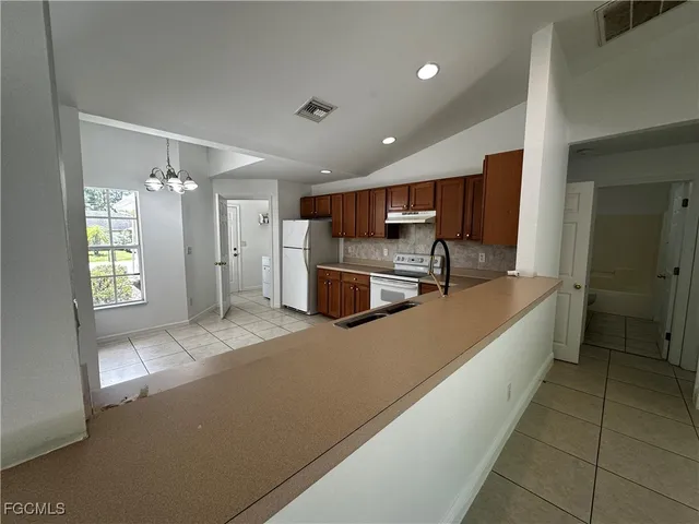 a large kitchen with a large window and stainless steel appliances