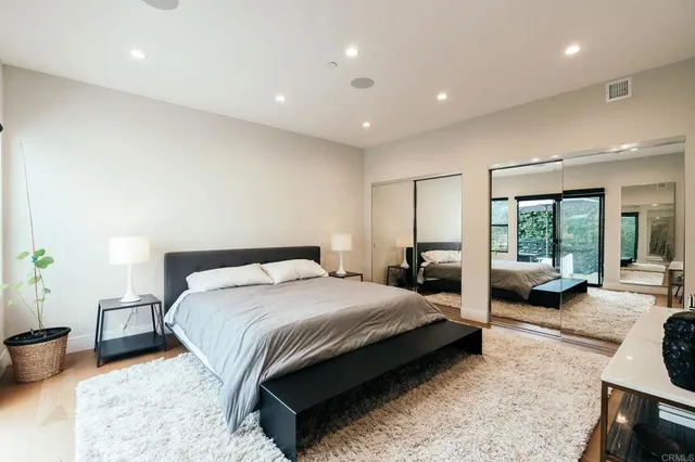 a view of a patio with couches table and chairs under an umbrella with a barbeque