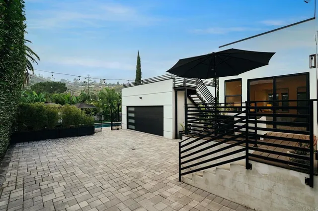 a view of a white house with a yard and potted plants