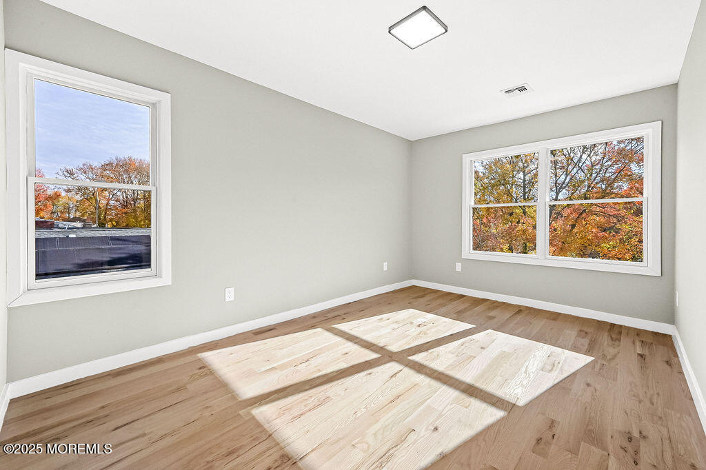 940 Grove Avenue Old Bridge, NJ 08879 - Photo 23 of 48 a view of an empty room with wooden floor and a window