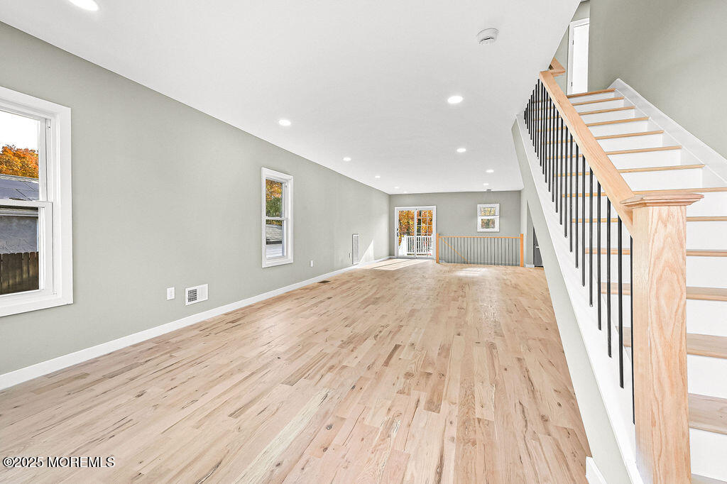 940 Grove Avenue Old Bridge, NJ 08879 - Photo 6 of 48 a view of an empty room with wooden floor and stairs