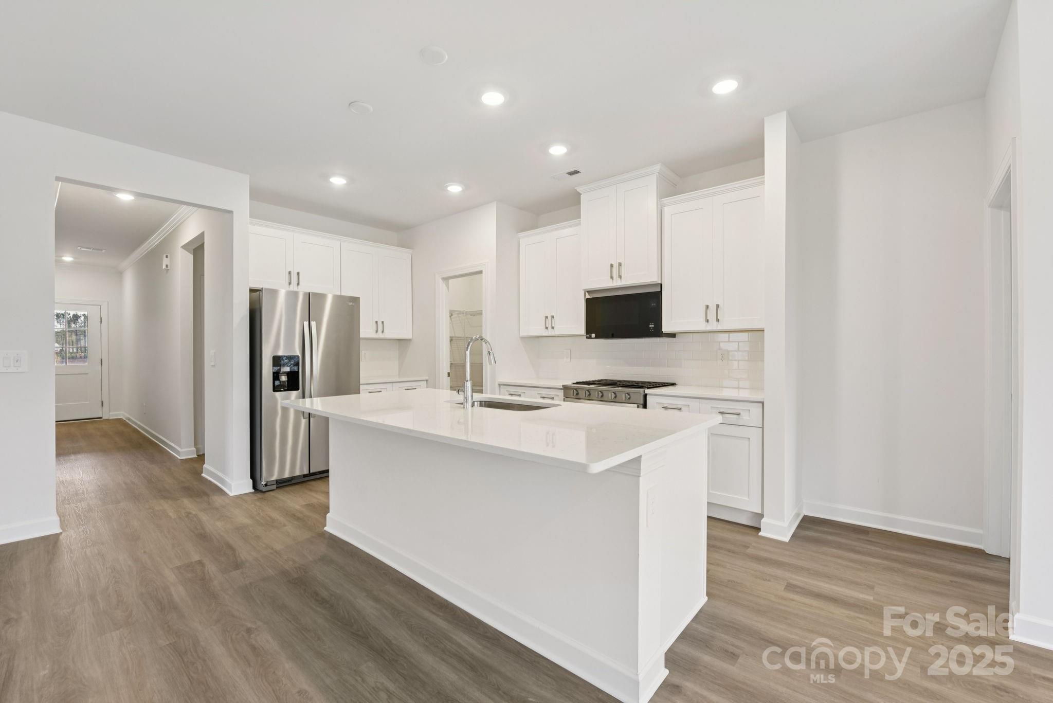 712 Palmer Pendleton Way York, SC 29745 - Photo 8 of 36 a kitchen with stainless steel appliances a stove top oven a refrigerator and white cabinets with wooden floor
