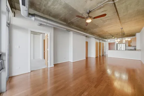a view of a livingroom with wooden floor and a ceiling fan