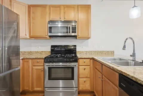 a kitchen with stainless steel appliances granite countertop a sink stove and microwave