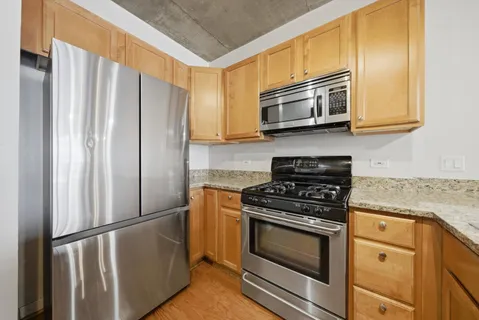 a kitchen with stainless steel appliances granite countertop a refrigerator stove and microwave