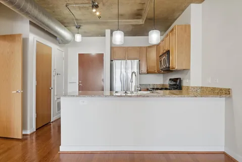 a kitchen with stainless steel appliances granite countertop a sink a stove and a refrigerator