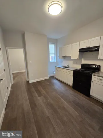 a kitchen with granite countertop a stove a sink and a refrigerator