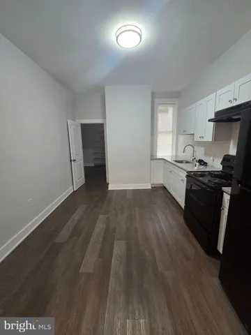 a kitchen with granite countertop a sink dishwasher stove and wooden floor
