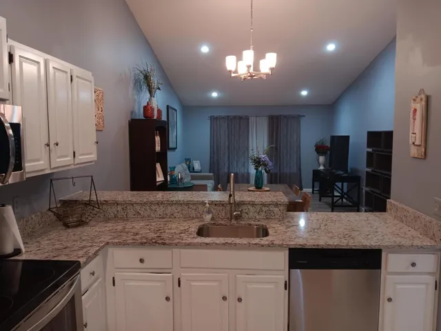 a view of kitchen with stainless steel appliances granite countertop cabinets and sink