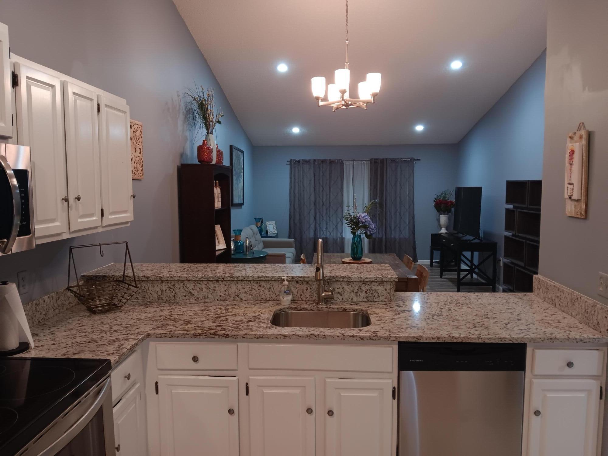 12989 Odessa Trail, Unit 3 Wellington, FL 33414 - Photo 12 of 32 a kitchen with kitchen island granite countertop stainless steel appliances a sink a counter space and cabinets