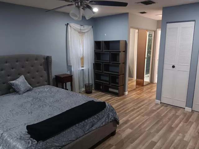 a bedroom with a bed and wooden floor