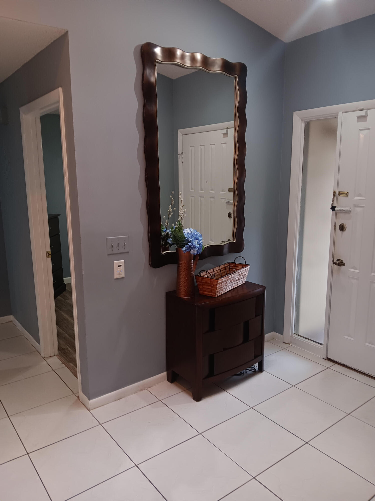 12989 Odessa Trail, Unit 3 Wellington, FL 33414 - Photo 5 of 32 a room with a mirror and a wooden table