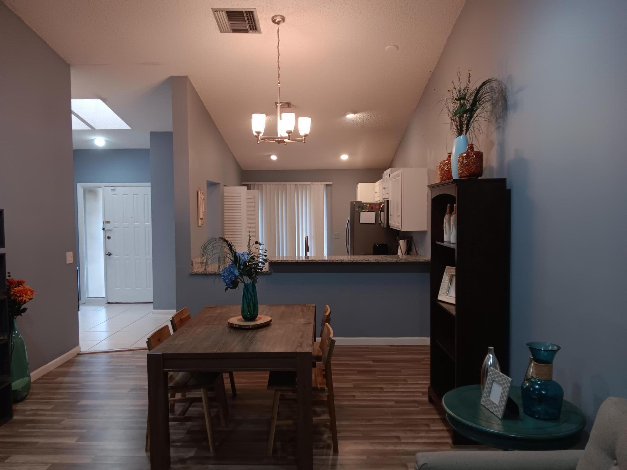 12989 Odessa Trail, Unit 3 Wellington, FL 33414 - Photo 7 of 32 a kitchen with stainless steel appliances a sink cabinets and wooden floor