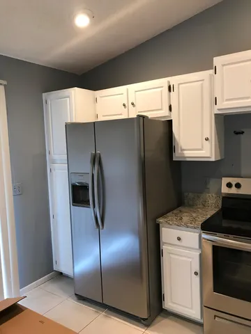 a kitchen with stainless steel appliances a refrigerator stove and white cabinets