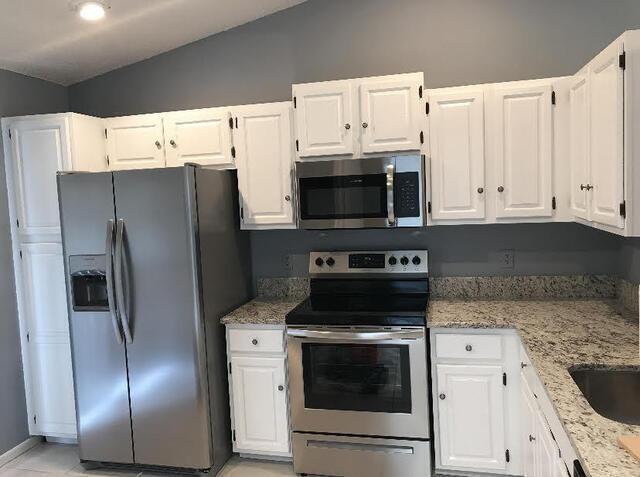 12989 Odessa Trail, Unit 3 Wellington, FL 33414 - Photo 10 of 32 a kitchen with stainless steel appliances a refrigerator stove and white cabinets