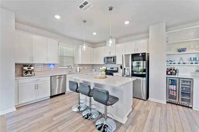 a kitchen with a sink a stove a refrigerator and white cabinets